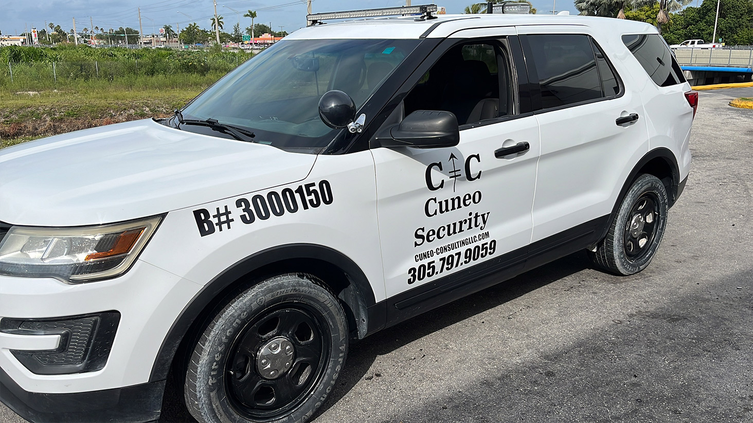 Cuneo Consulting security patrol vehicle parked outdoors, showcasing company branding and contact information.