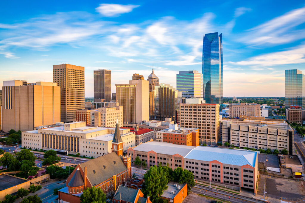 Oklahoma City skyline at dusk with clear skies, showcasing modern and historical buildings.
