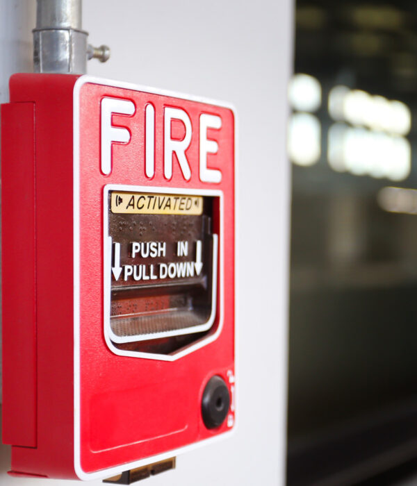 Close-up of a red fire alarm activation station with instructions to push in and pull down.