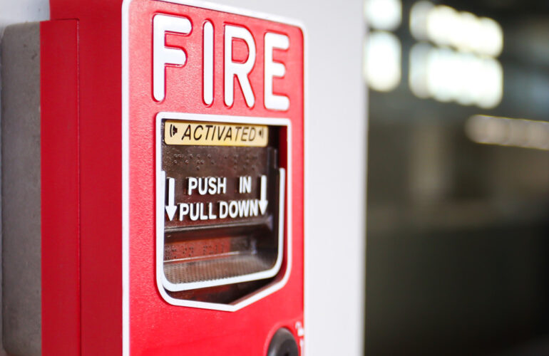 Close-up of a red fire alarm activation station with instructions to push in and pull down.